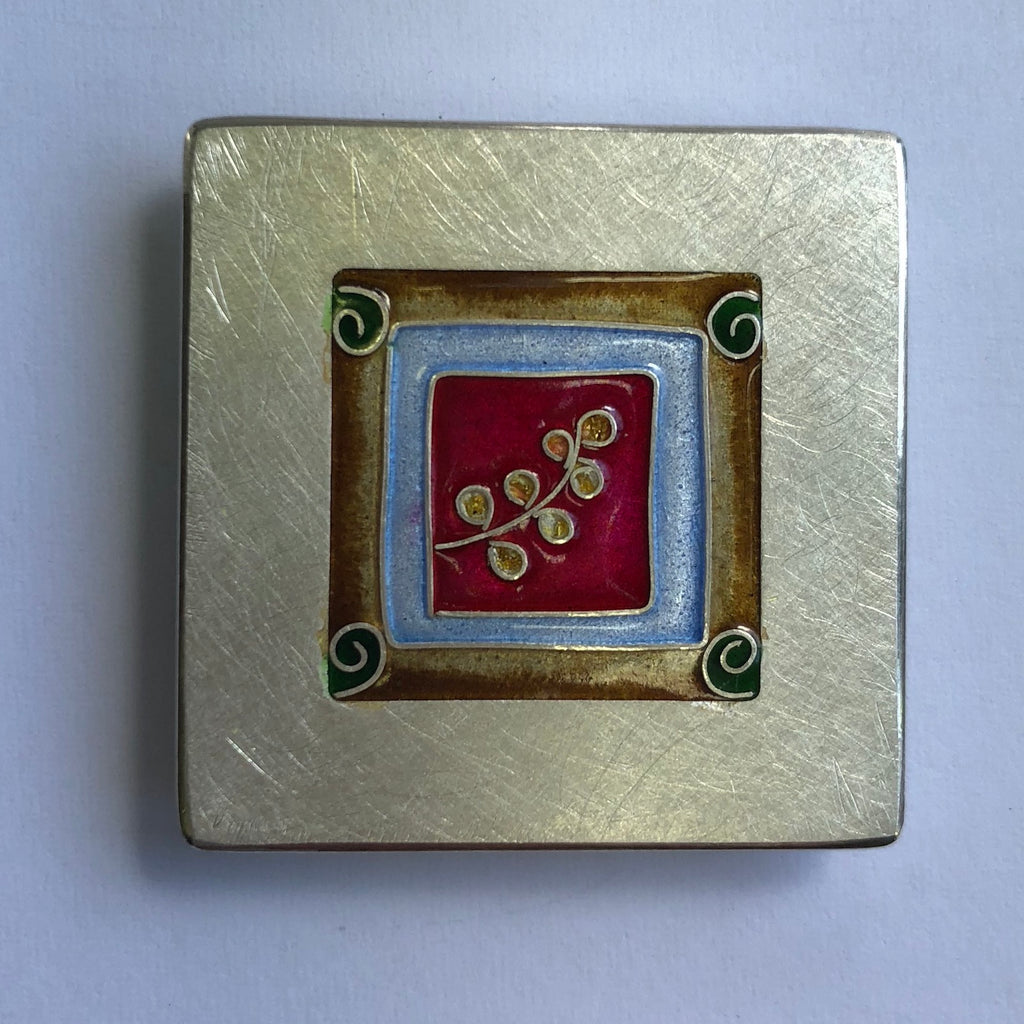 Brooch, small leaf on red with koru's